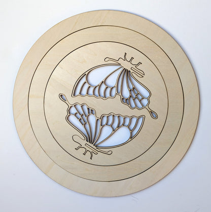 Wooden circular cutout with butterfly design on a white background